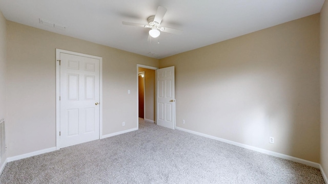 unfurnished bedroom featuring ceiling fan and carpet