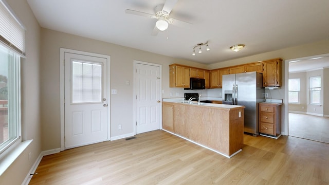 kitchen featuring kitchen peninsula, sink, ceiling fan, stainless steel fridge with ice dispenser, and light hardwood / wood-style flooring