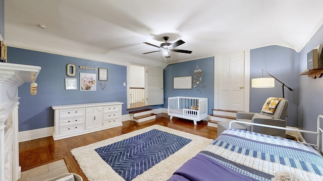 bedroom with dark hardwood / wood-style flooring, ornamental molding, and ceiling fan