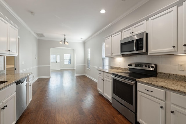 kitchen featuring white cabinetry, appliances with stainless steel finishes, crown molding, and light stone countertops