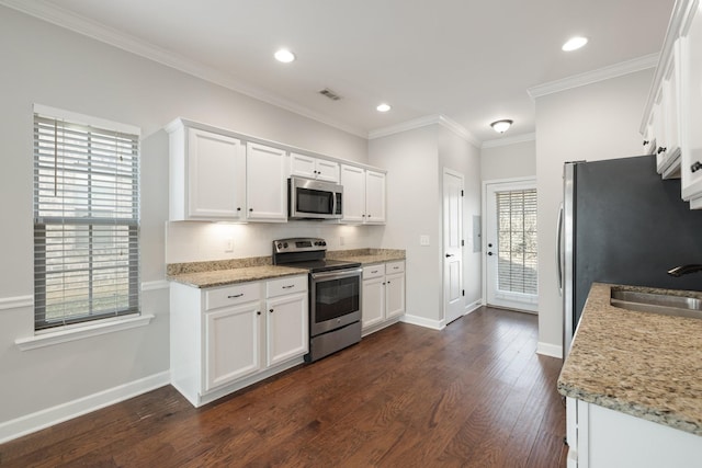 kitchen featuring white cabinetry, sink, light stone counters, and appliances with stainless steel finishes