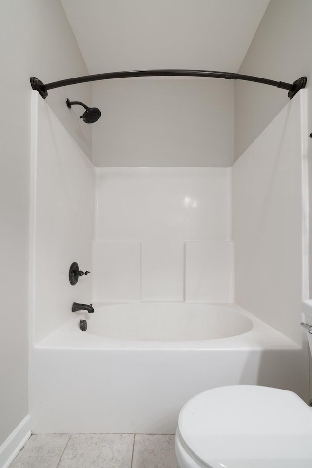 bathroom featuring tile patterned flooring, tub / shower combination, and toilet