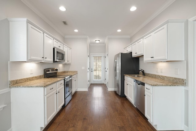 kitchen featuring light stone countertops, dark hardwood / wood-style floors, white cabinets, and appliances with stainless steel finishes