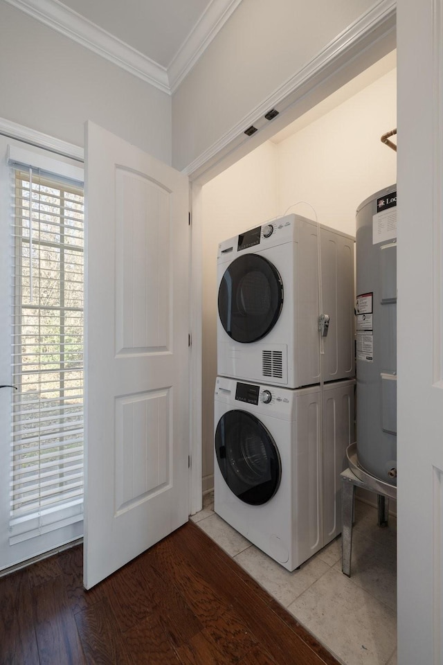 washroom with stacked washer and dryer, ornamental molding, wood-type flooring, and water heater