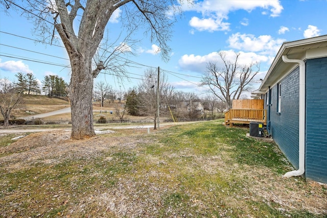 view of yard featuring central AC and a deck