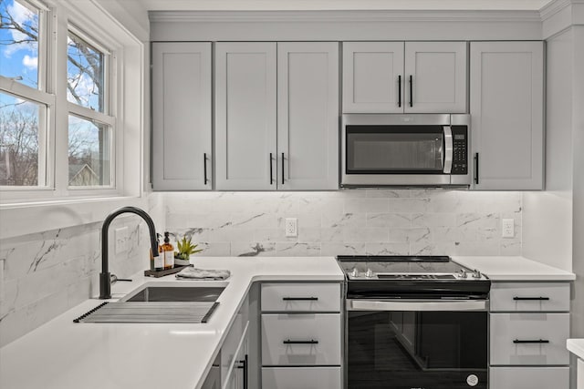 kitchen featuring tasteful backsplash, sink, and range with electric stovetop