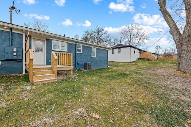 back of property featuring cooling unit and a lawn