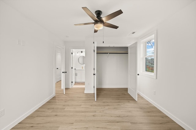 unfurnished bedroom featuring ceiling fan, connected bathroom, light hardwood / wood-style floors, and a closet