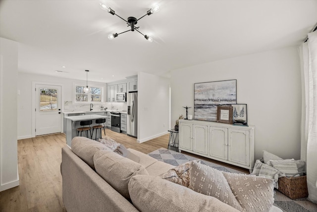 living room featuring sink and light hardwood / wood-style flooring