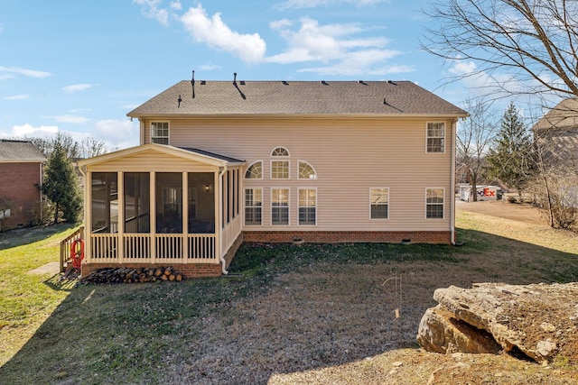 rear view of house featuring a sunroom and a lawn