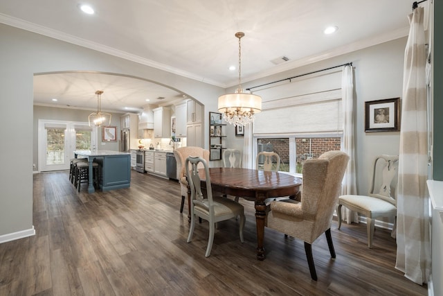 dining area featuring dark wood-type flooring, crown molding, and a chandelier