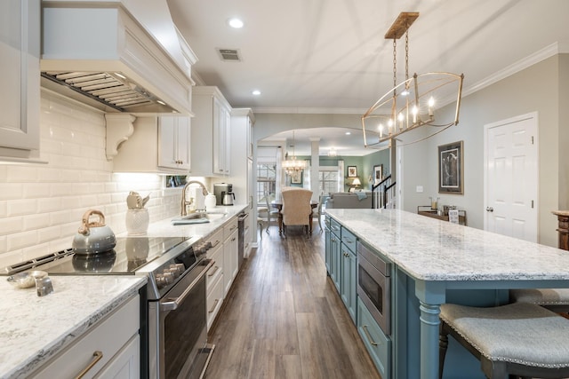 kitchen with a kitchen island, stainless steel appliances, white cabinets, and premium range hood