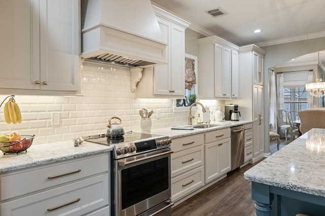 kitchen featuring stainless steel appliances, premium range hood, sink, and white cabinets