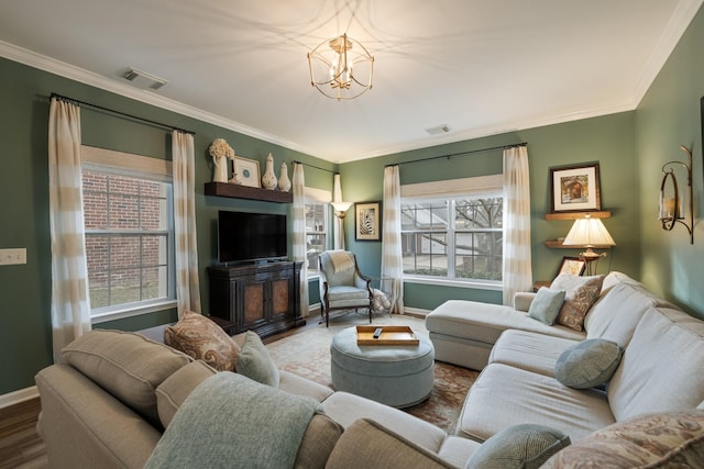 living room with wood-type flooring, ornamental molding, and a chandelier