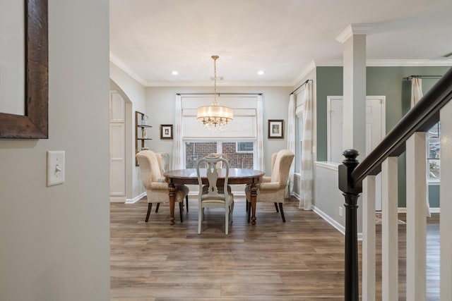 dining room featuring a notable chandelier, hardwood / wood-style flooring, ornamental molding, and a healthy amount of sunlight