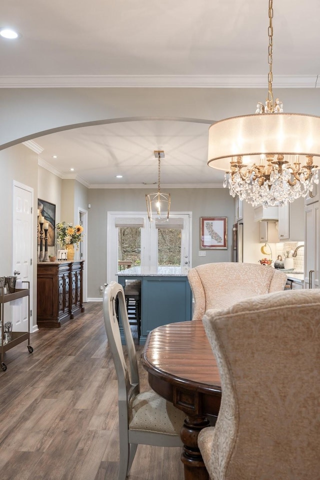 dining space featuring hardwood / wood-style flooring, crown molding, and wine cooler