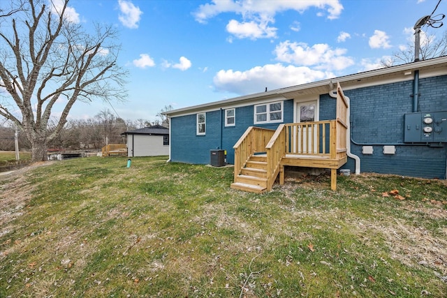 rear view of property featuring a yard and central AC unit