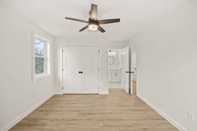 unfurnished bedroom with ceiling fan, a closet, connected bathroom, and light hardwood / wood-style flooring