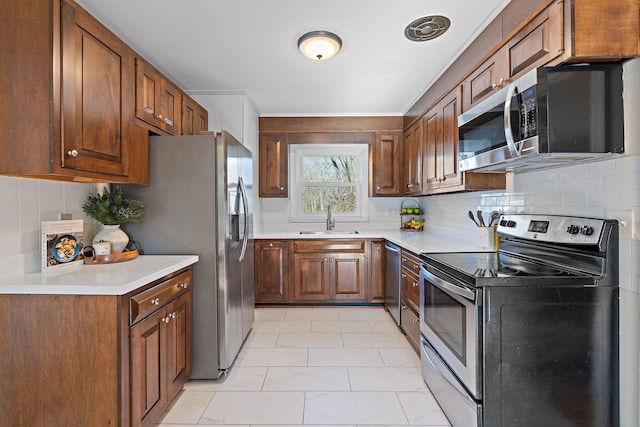 kitchen with stainless steel appliances, sink, and backsplash