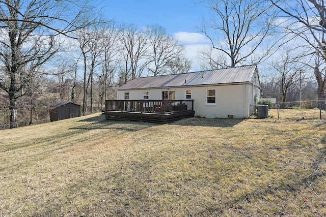 back of property featuring a shed, a wooden deck, a lawn, and central air condition unit