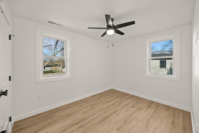 spare room with a healthy amount of sunlight, ceiling fan, and light hardwood / wood-style flooring