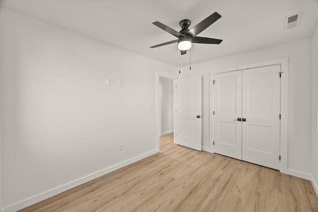 unfurnished bedroom featuring ceiling fan, light hardwood / wood-style floors, and a closet