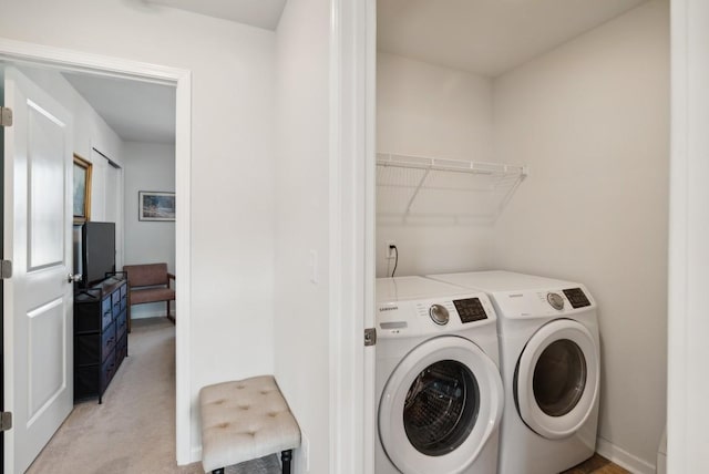 laundry area with washer and dryer and light colored carpet