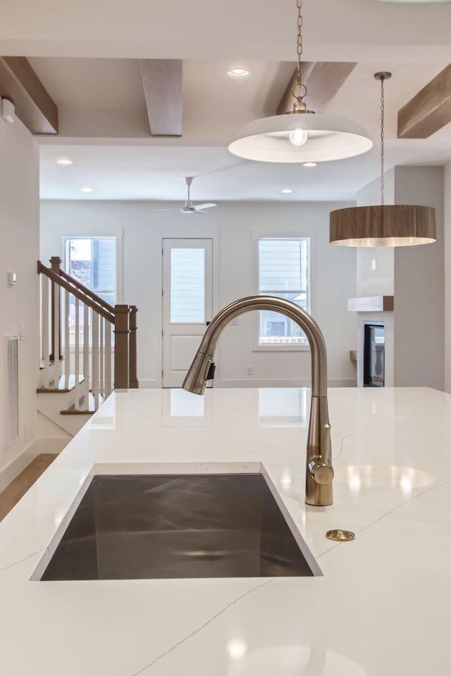 details featuring sink, pendant lighting, and light stone counters