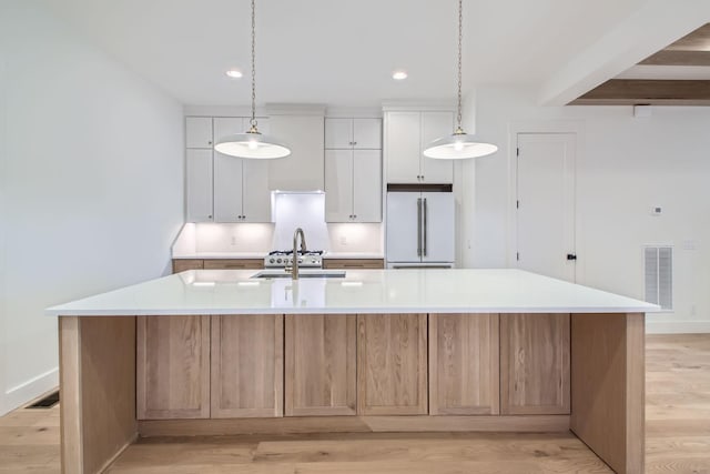 kitchen featuring a large island, white cabinets, and white refrigerator