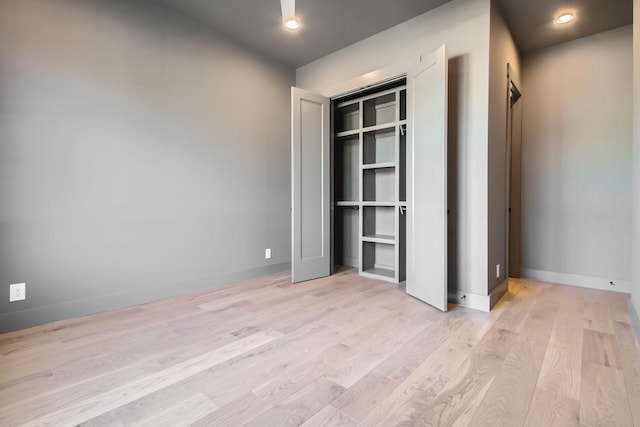 unfurnished bedroom featuring a closet and light wood-type flooring