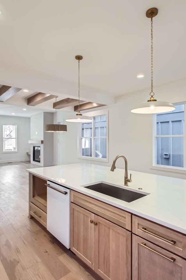 kitchen with light hardwood / wood-style floors, dishwasher, sink, and hanging light fixtures