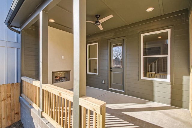 doorway to property with an outdoor fireplace, ceiling fan, and a patio area