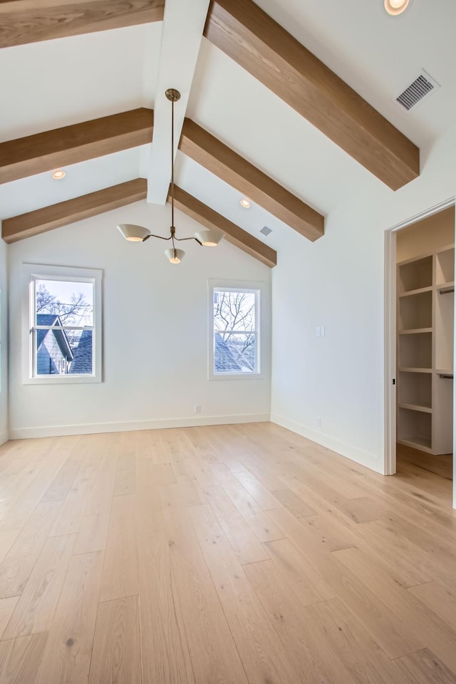 unfurnished living room featuring vaulted ceiling with beams and light wood-type flooring