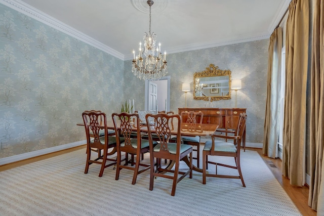 dining room with ornamental molding, a chandelier, and light hardwood / wood-style floors