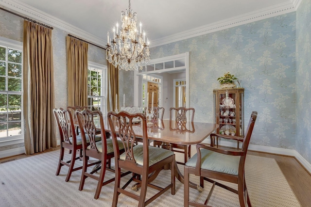 dining space featuring a notable chandelier, light hardwood / wood-style flooring, and ornamental molding