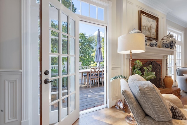 doorway to outside with hardwood / wood-style flooring, crown molding, and a brick fireplace