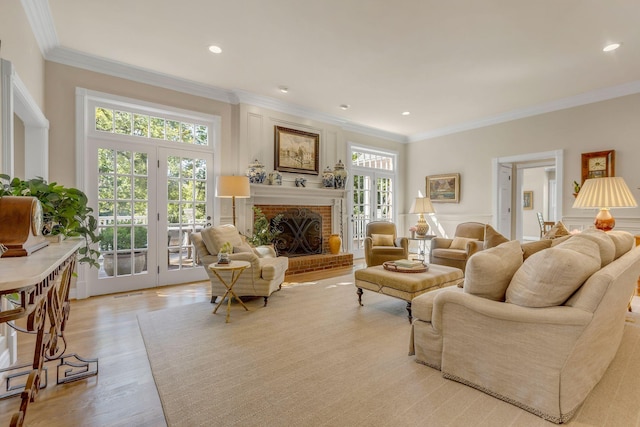 living room featuring ornamental molding, light hardwood / wood-style floors, and a brick fireplace