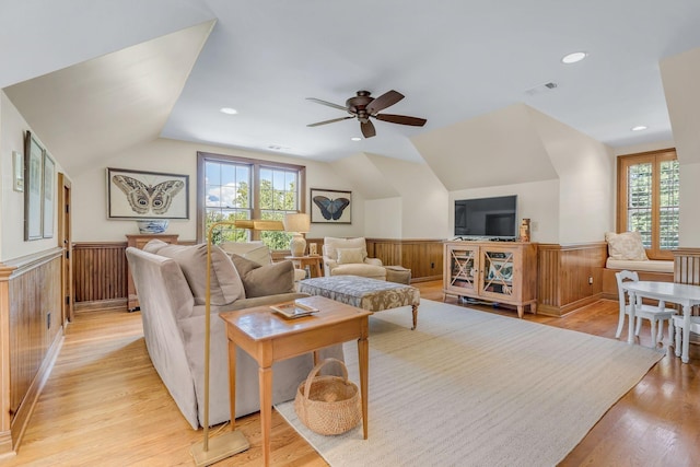 living room with ceiling fan, a healthy amount of sunlight, vaulted ceiling, and light hardwood / wood-style flooring