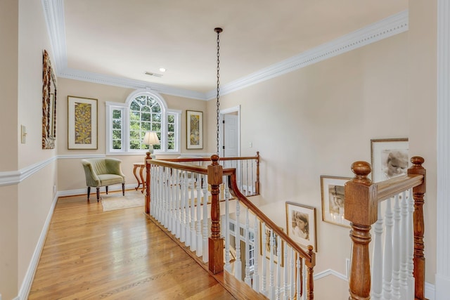 hall featuring ornamental molding and light hardwood / wood-style floors