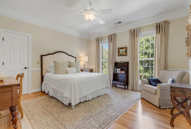 bedroom with ornamental molding, ceiling fan, and light hardwood / wood-style flooring