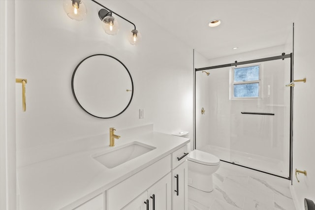 bathroom featuring vanity, a shower with door, and toilet