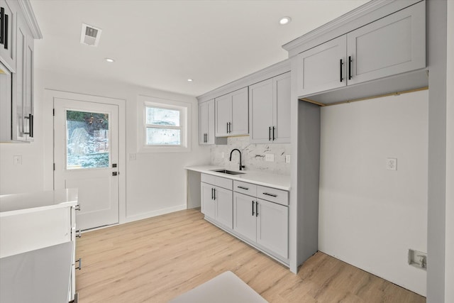 kitchen featuring sink, backsplash, and light hardwood / wood-style floors