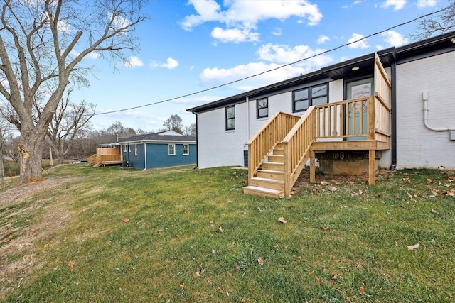 back of property featuring a yard and a deck