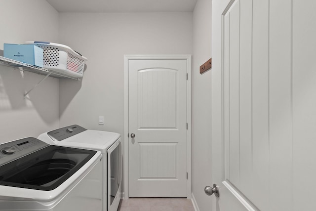 laundry room with separate washer and dryer and light tile patterned floors