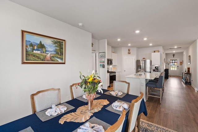 dining space with sink and dark wood-type flooring