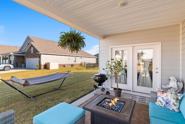 view of patio / terrace with a garage, grilling area, and an outdoor fire pit