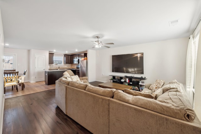 living room featuring dark hardwood / wood-style floors and ceiling fan