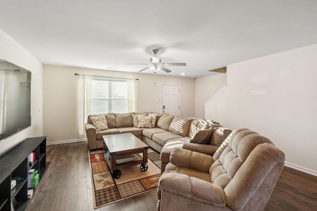 living room featuring dark wood-type flooring and ceiling fan