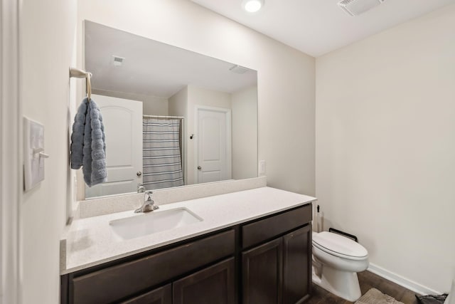 bathroom featuring vanity, hardwood / wood-style floors, walk in shower, and toilet