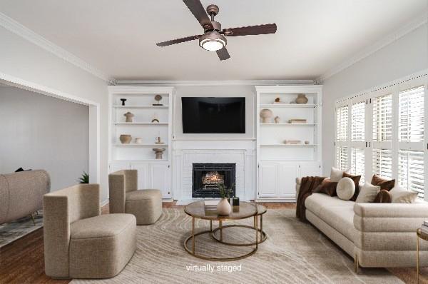 living room featuring crown molding, ceiling fan, built in shelves, and hardwood / wood-style floors